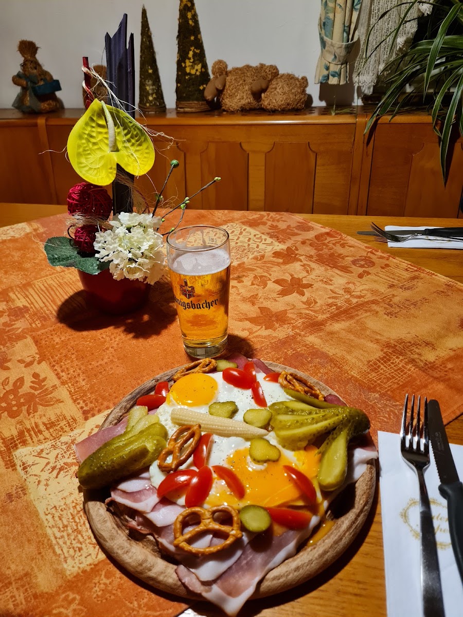 Deftige Vesperplatte mit Schinken, Spiegeleiern und Gurken, dazu ein Königsbacher Bier